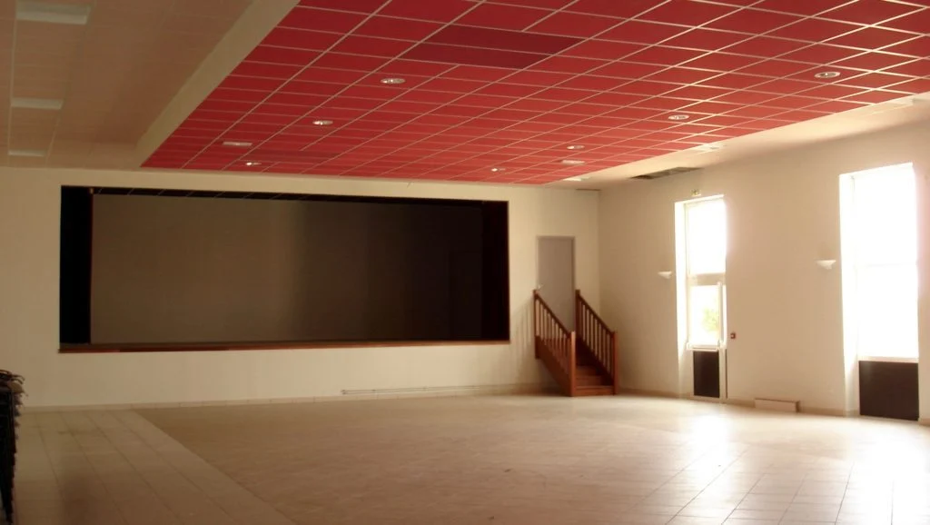 La grande salle vue depuis l’entrée, avec son escalier vers la scène.