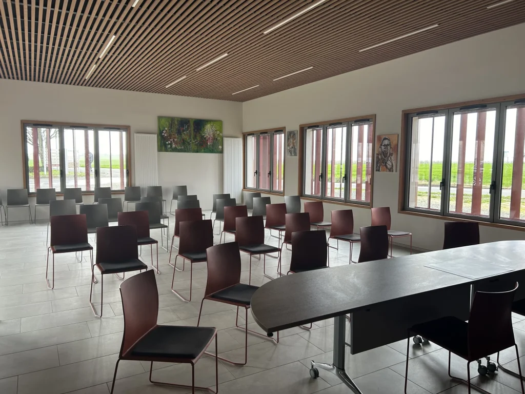 La salle du conseil municipal, avec sa grande table ovale et ses fenêtres sur la campagne.
