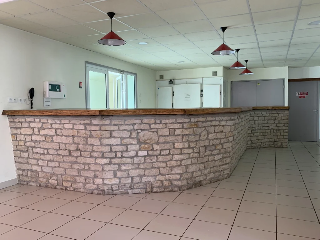 Un comptoir en pierre dans un hall de salle communale.